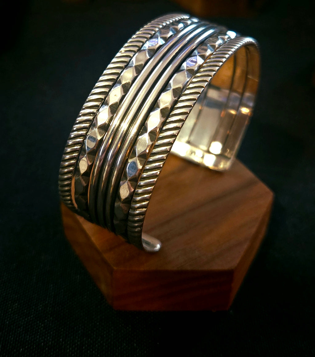 Sterling silver 5 band cuff bracelet with textured and faceted details. 
