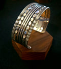 Sterling silver 5 band cuff bracelet with textured and faceted details. 
