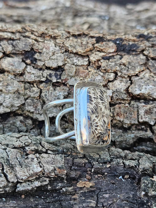  adjustable sterling silver ring showcases ancient 20-million-year-old Indonesian fossilized coral with a striking stingray pattern. Fits sizes 7-10.