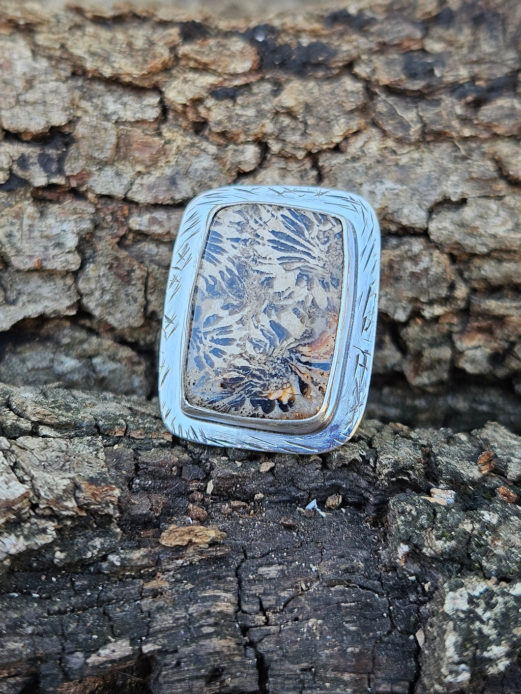  adjustable sterling silver ring showcases ancient 20-million-year-old Indonesian fossilized coral with a striking stingray pattern. Fits sizes 7-10.