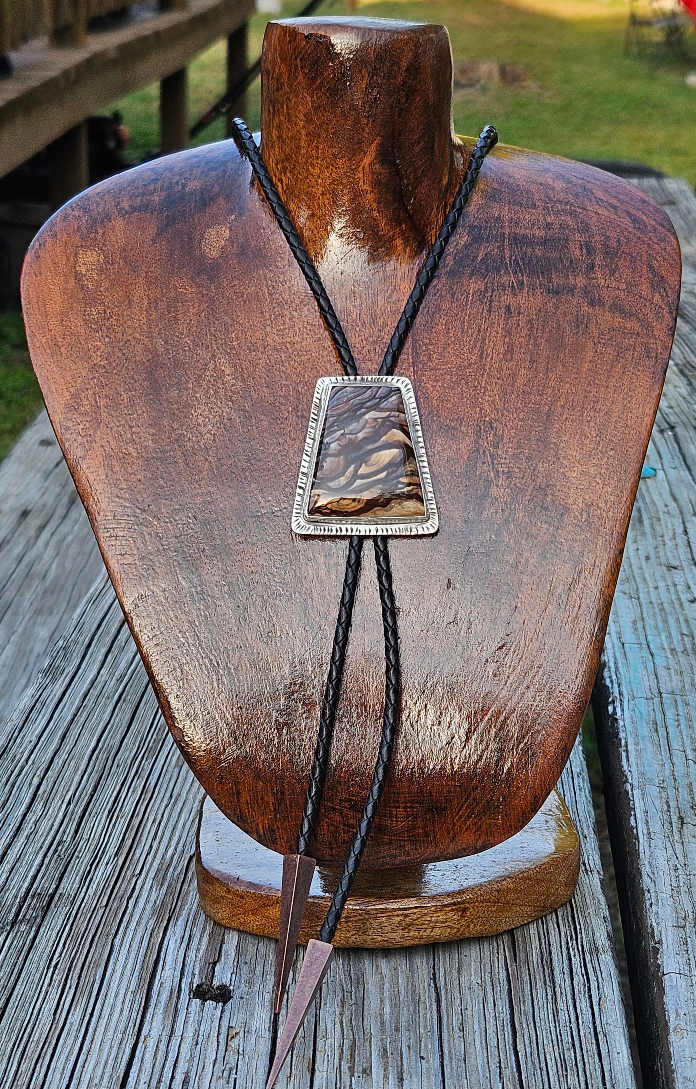 Rectangular Biggs Jasper Bolo Tie set in sterling sliver with a blacl leather cord and triangular copper tips 