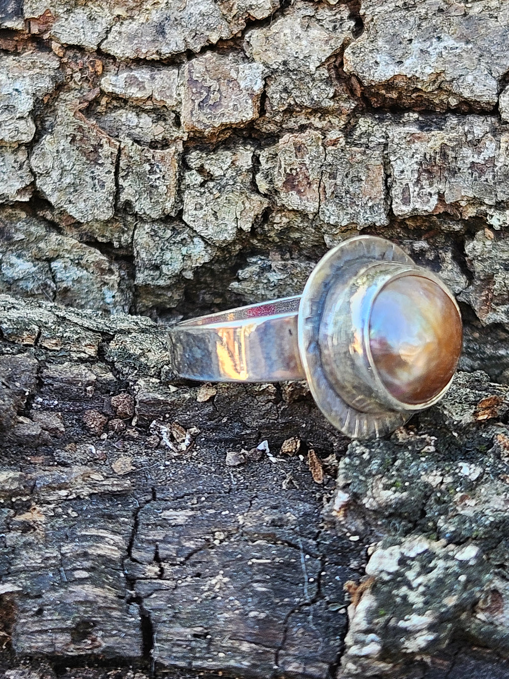 Rising Sun Ring setting with a textured backplate featuring a round rosegold mother of pearl set in sterling silver. Size 7