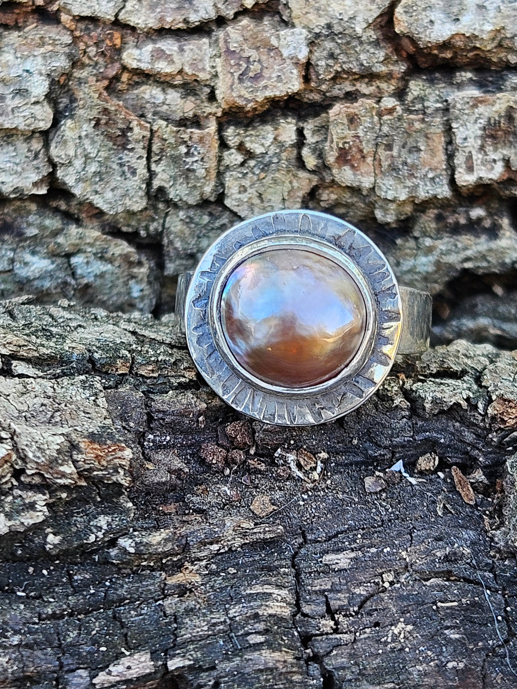 Rising Sun Ring setting with a textured backplate featuring a round rosegold mother of pearl set in sterling silver. Size 7