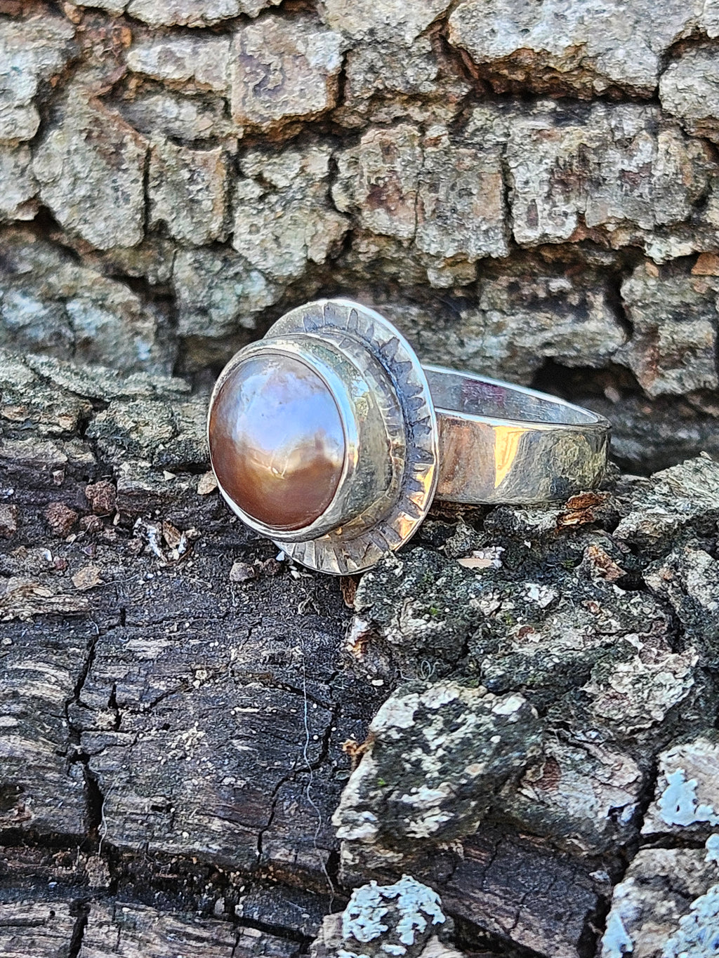 Rising Sun Ring setting with a textured backplate featuring a round rosegold mother of pearl set in sterling silver. Size 7