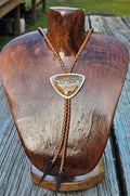 Owyhee Blue Sky Picture Jasper Bolo set in sterling silver with a textured border and a light brown leather cord with triangular antique silver tips.