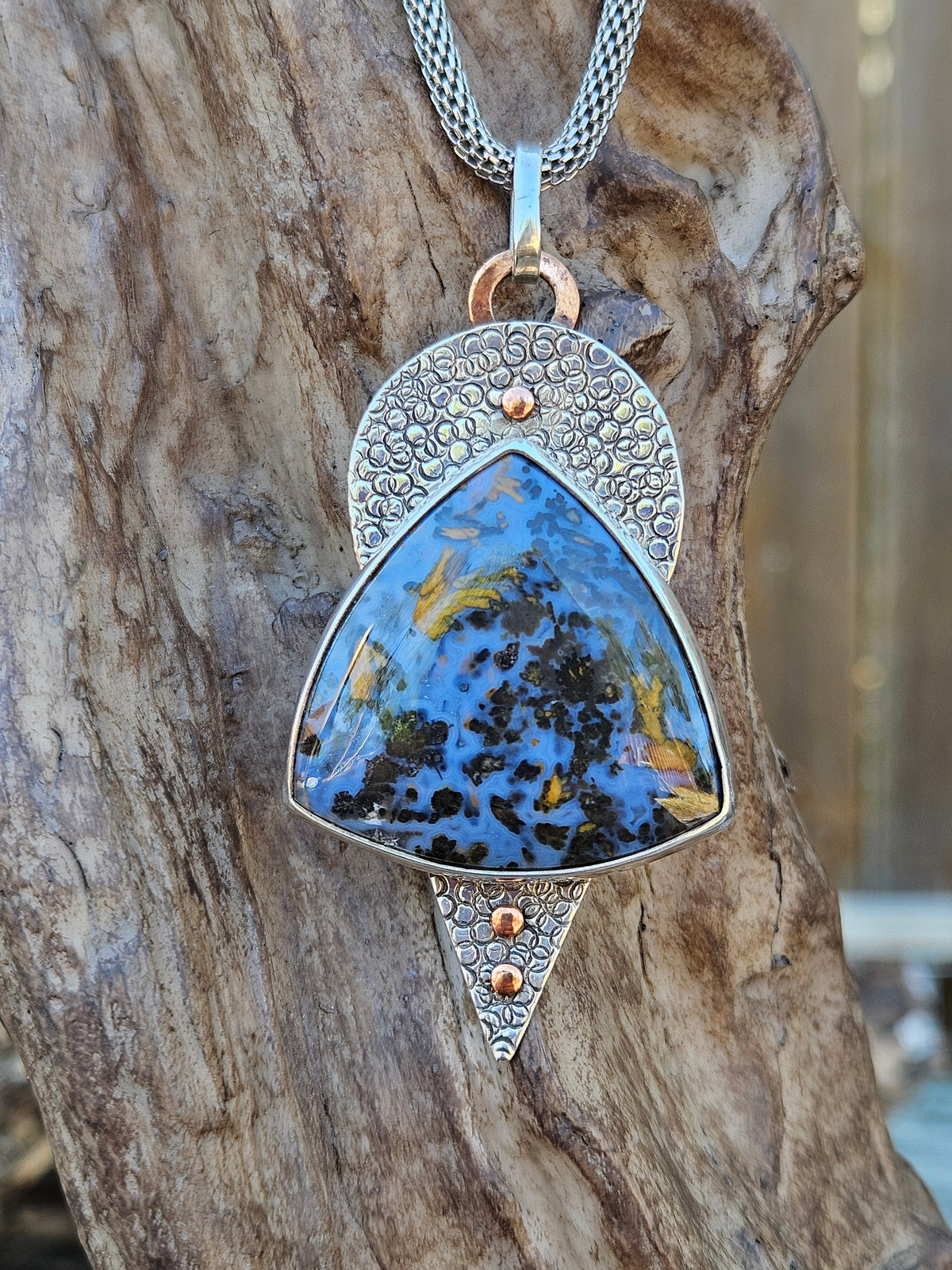 Large blue and copper colored Pietersite pendant set in sterling silver. Hand textured backplate with copper accents 