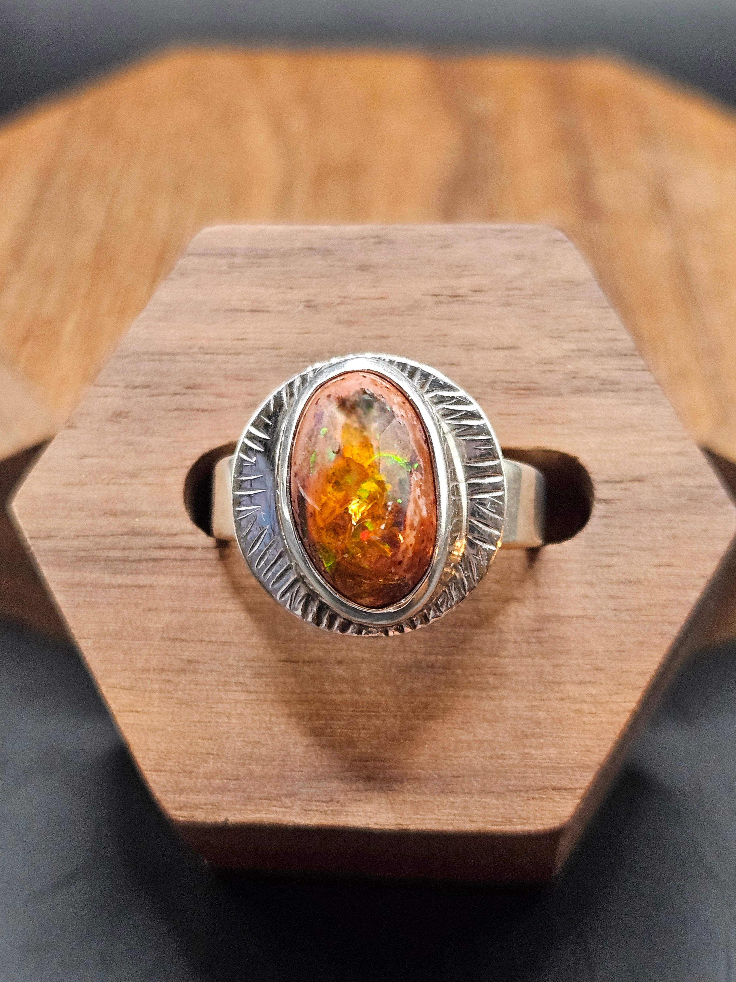 Oval shaped Mexican Matrix Opal featuring a fiery orange and yellow internal inlay with a textured background set in sterling silver. Size 7.25