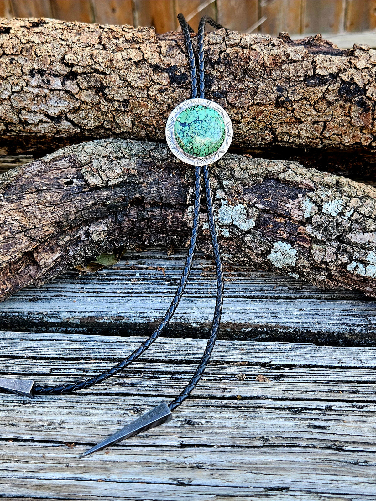 Round Hubei Spiderweb Turquoise Bolo set on sterling silver with a black braided leather cord and triangular antique silver tips 