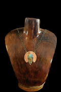 Royston turquoise pendant necklace with mixed metals. The pendant features a textured copper half-moon shape framing a central turquoise stone with brown and green matrix with a silver bezel and brass chain.