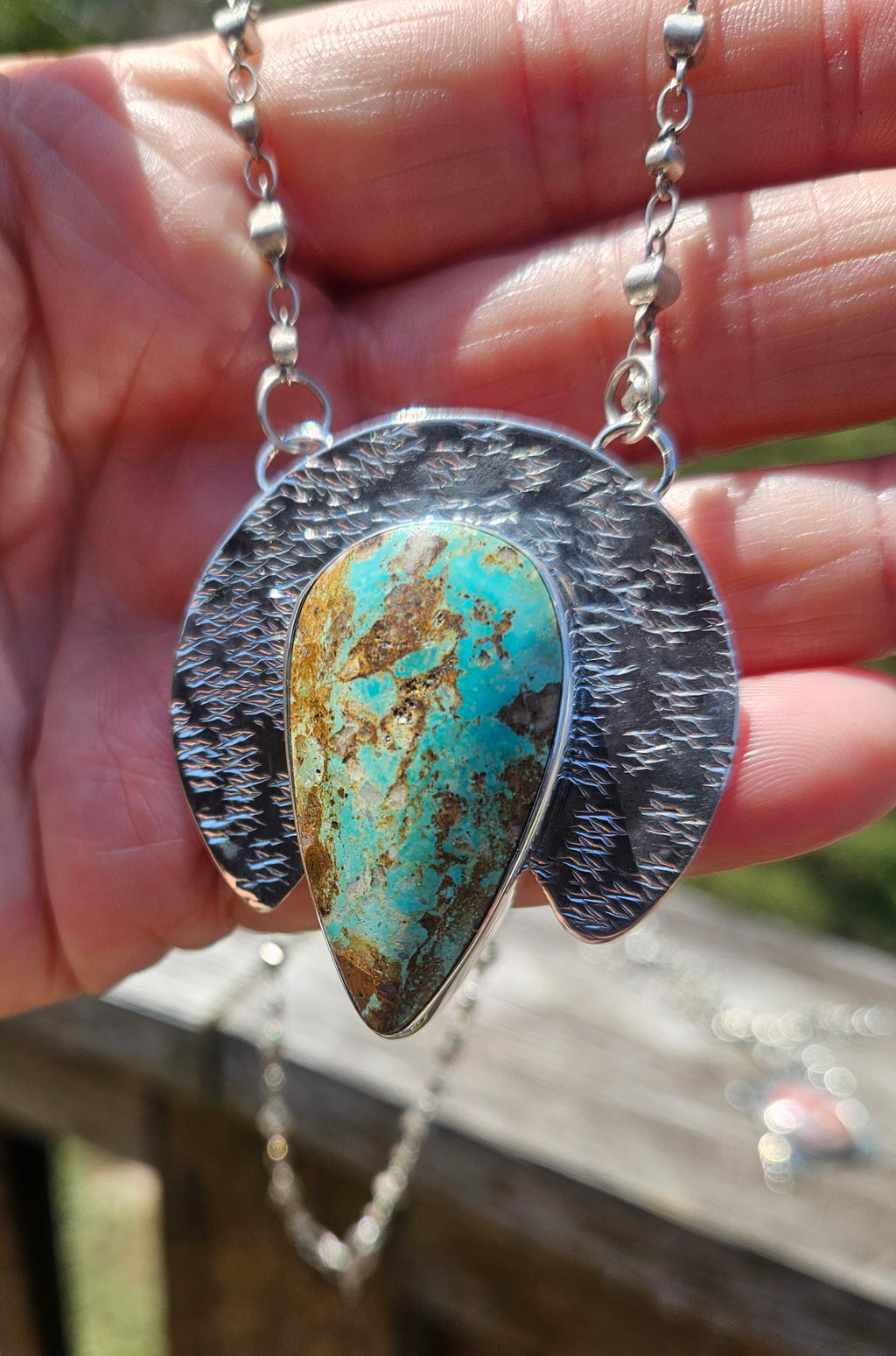 Royston Turquoise Teardrop Pendant set in sterling silver with a crescent backplate with a textured hand stamped finish.