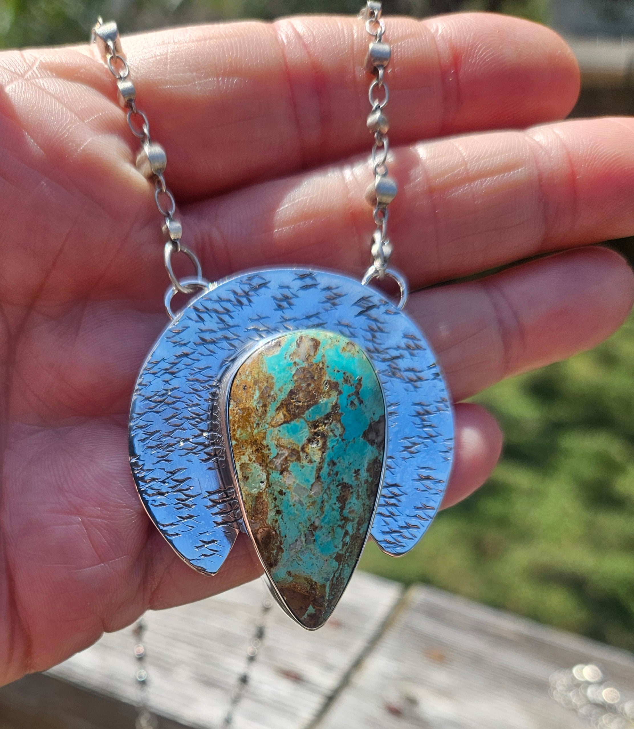 Royston Turquoise Teardrop Pendant set in sterling silver with a crescent backplate with a textured hand stamped finish.