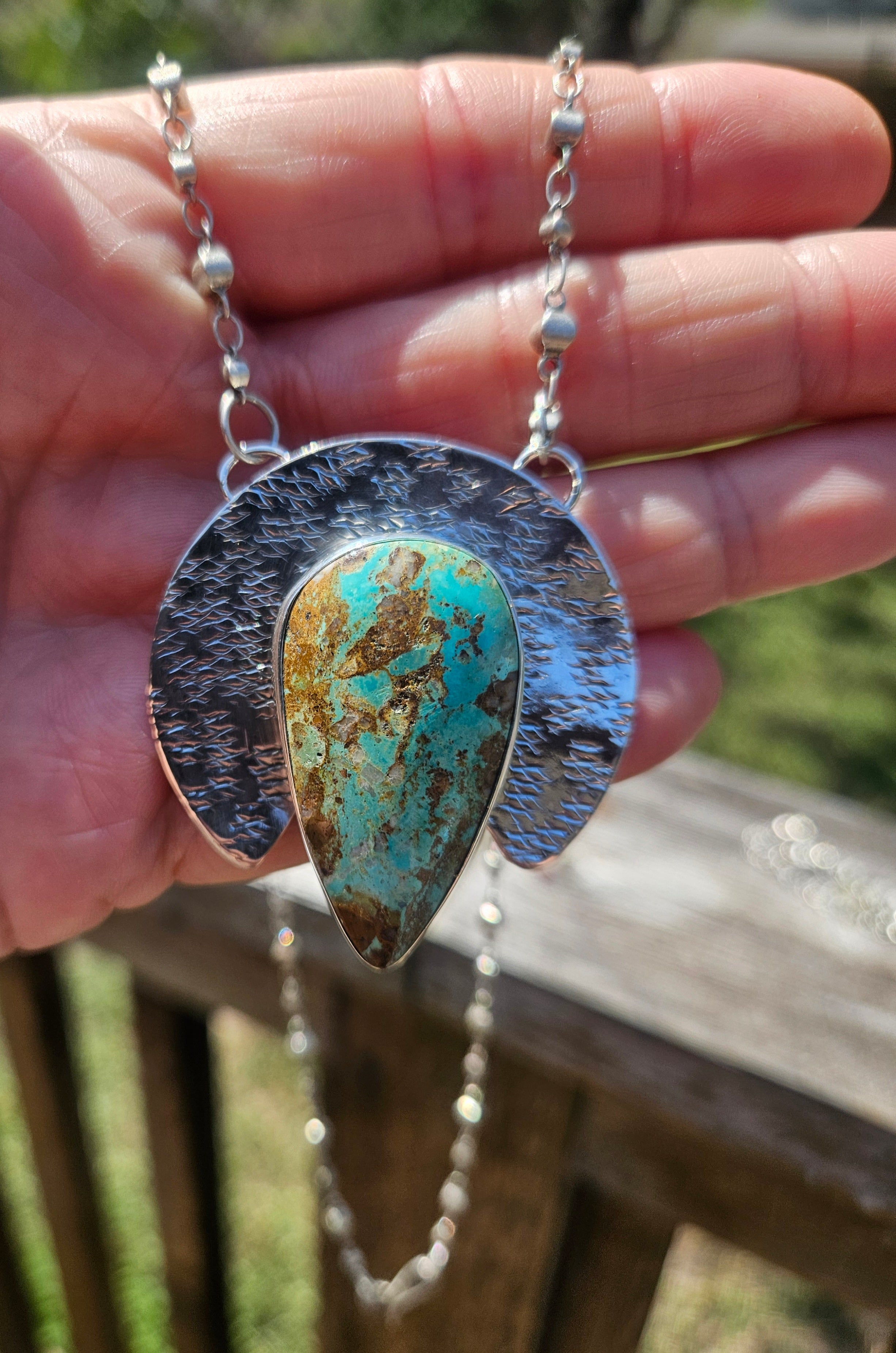 Royston Turquoise Teardrop Pendant set in sterling silver with a crescent backplate with a textured hand stamped finish.