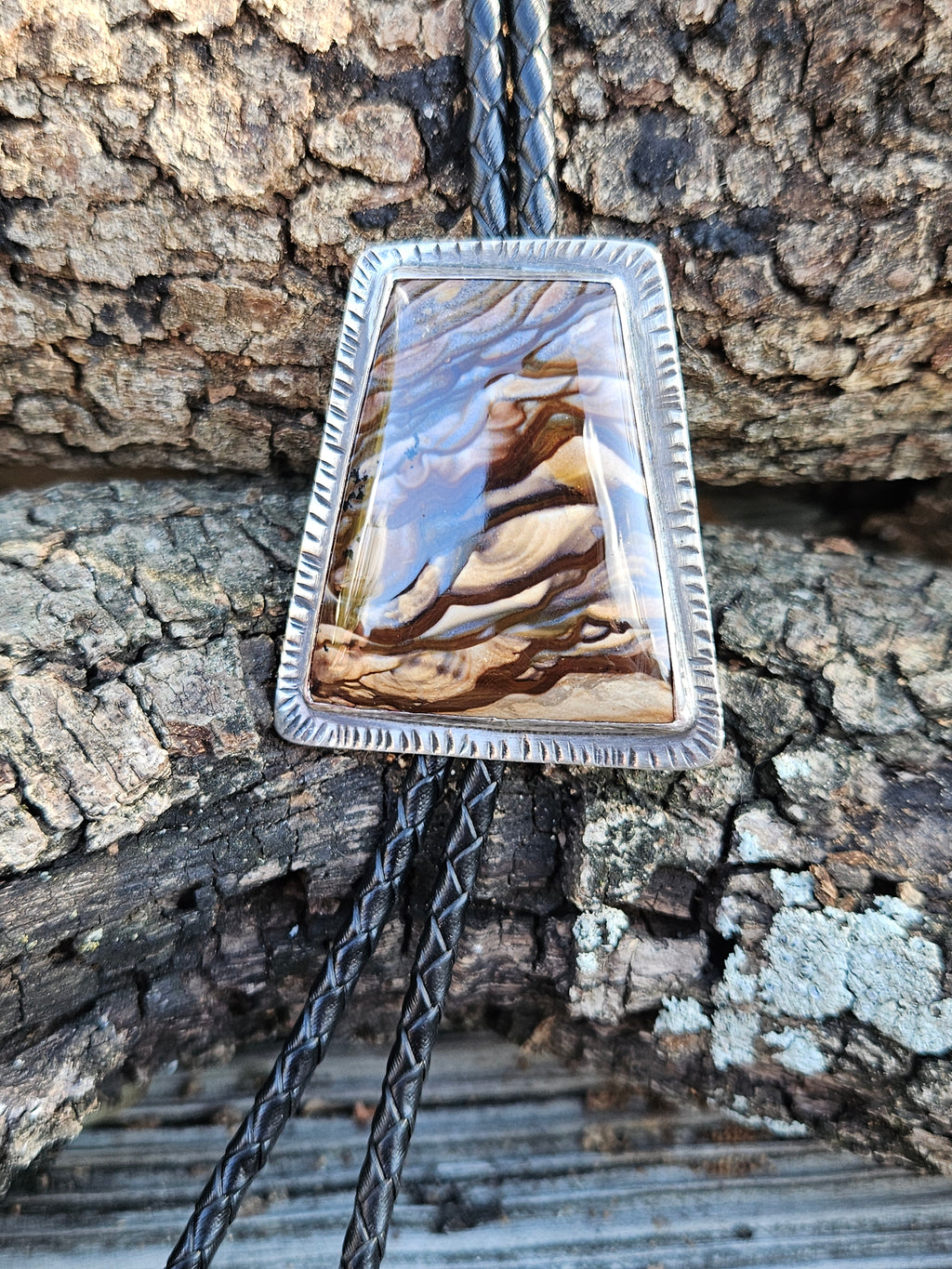 Rectangular sterling silver Biggs Jasper Bolo with black leather cord and copper triangular tips.