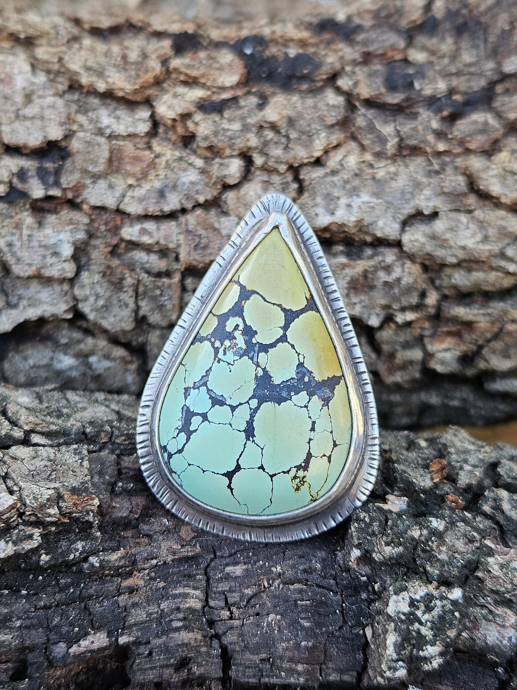 Teardrop Hubei Turquoise Ring set in sterling silver with a textured border. Ring band has 3 lines that are oxidized. Size 12