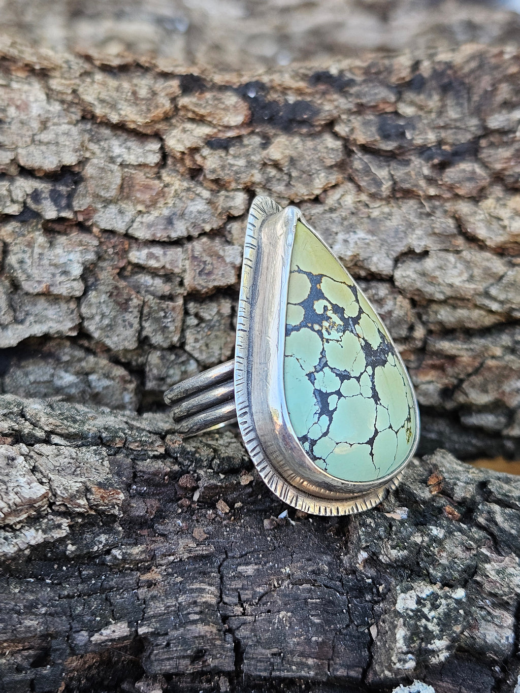 Teardrop Hubei Turquoise Ring set in sterling silver with a textured border. Ring band has 3 lines that are oxidized. Size 12