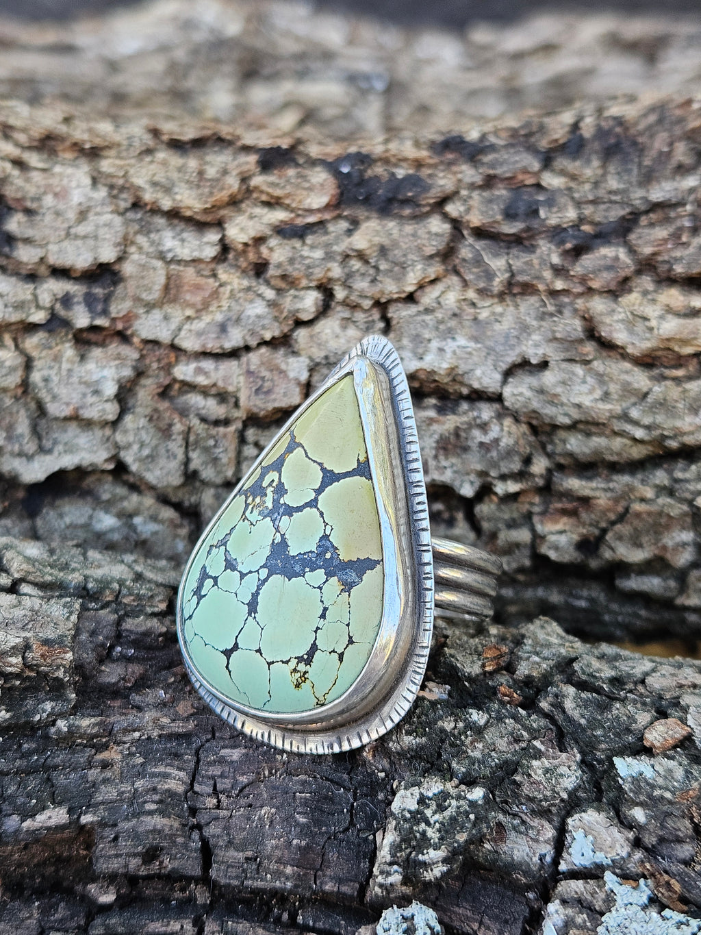 Teardrop Hubei Turquoise Ring set in sterling silver with a textured border. Ring band has 3 lines that are oxidized. Size 12