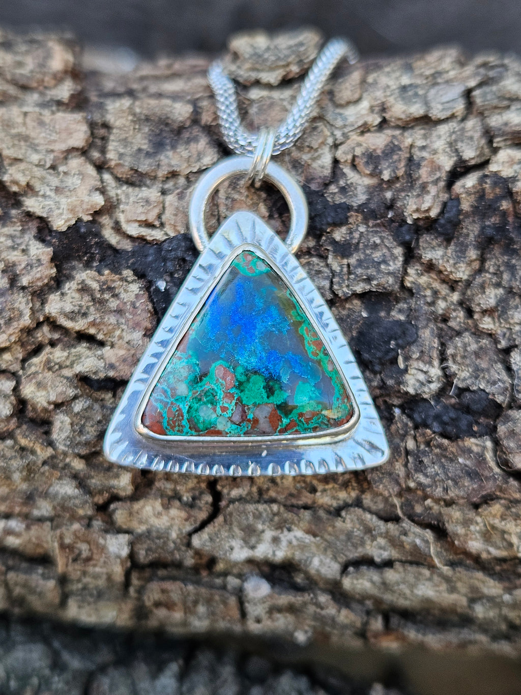 Triangular shaped Malachite Azurite Pendant set in sterling silver with a textured border. Green and blue colors.